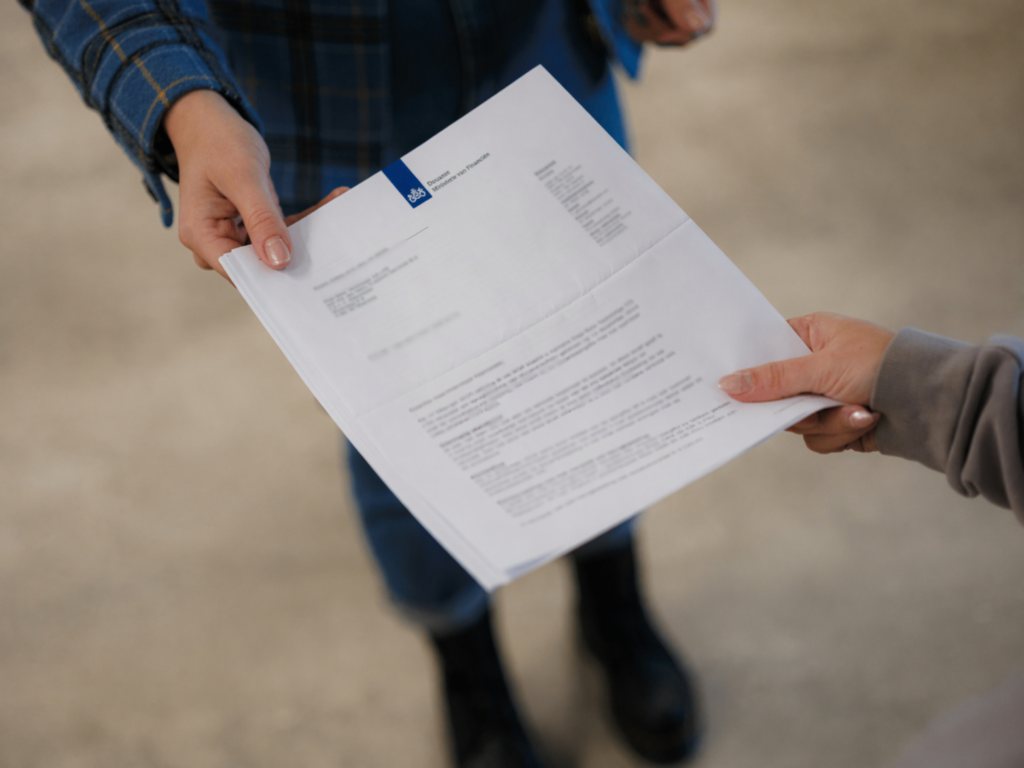 Two hands exchanging a letter.